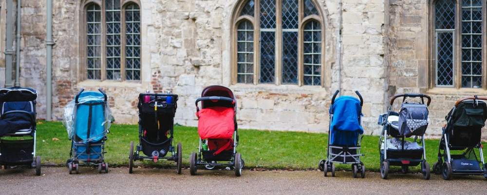 a line of strollers parked in front of building